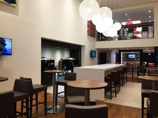 Here there is one of the three beverage areas, with machines for making hot drinks and fridges of sodas and waters. This little area has high bar tables with stools and a long central table, again with stools.